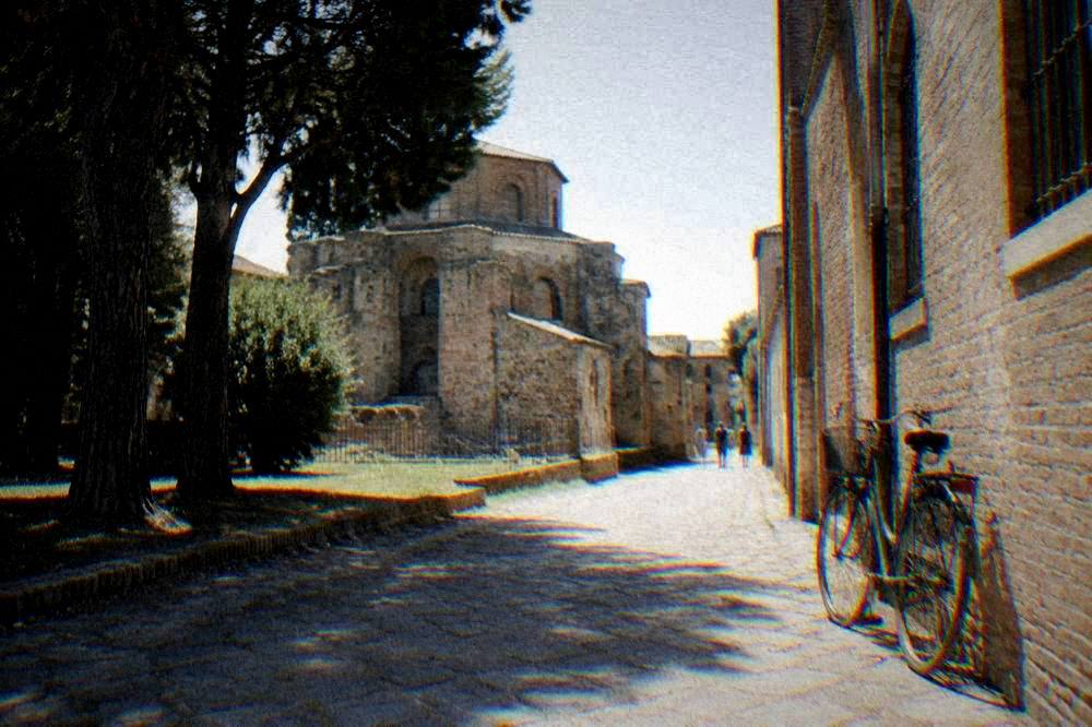 A stone-paved lane with old brick buildings and a bicycle leaning against a wall