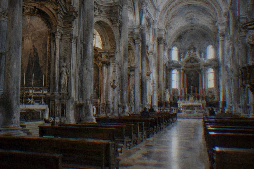 The interior nave of a baroque cathedral with columns and side chapels