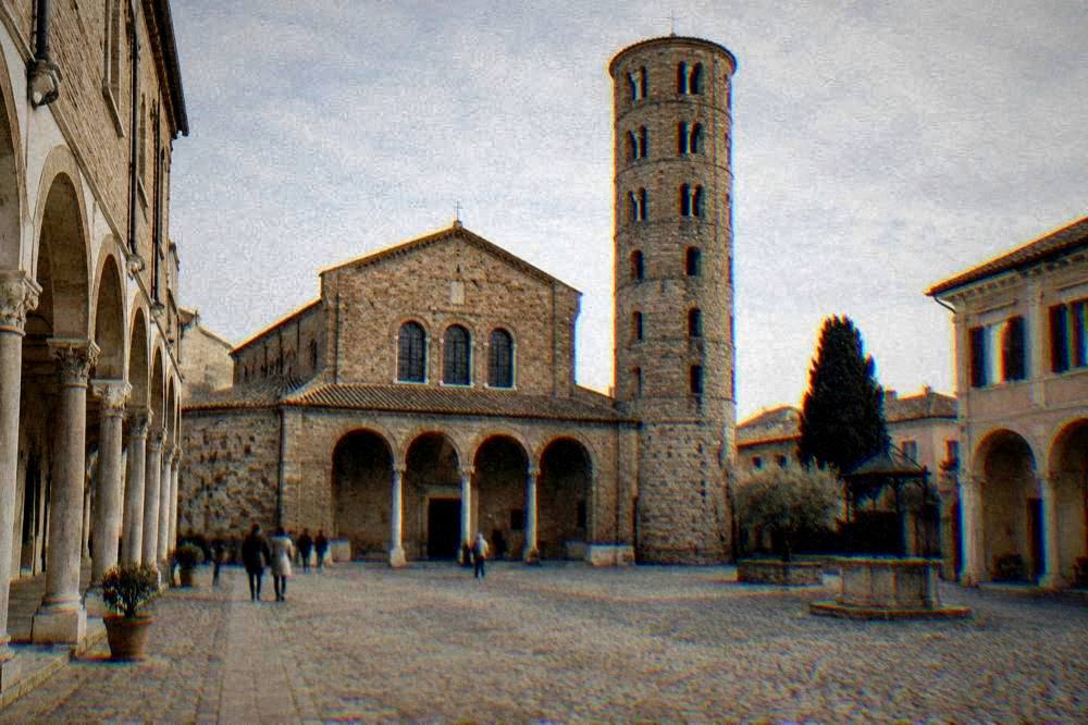 A quiet medieval piazza with arcaded buildings and a stone tower