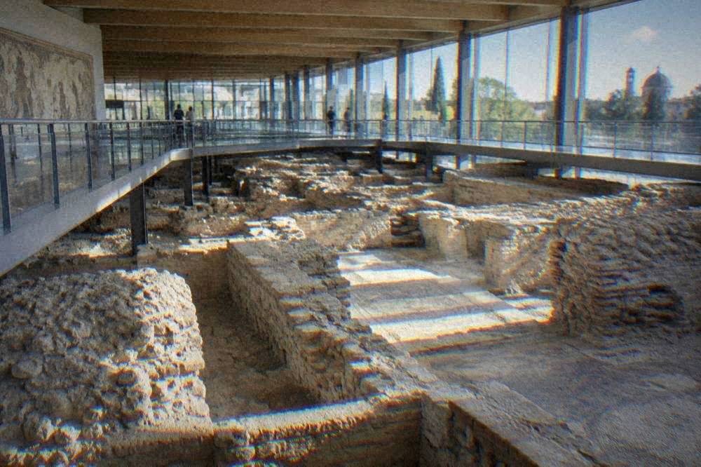 A modern museum hall with stone Roman foundations and walkways above the excavations