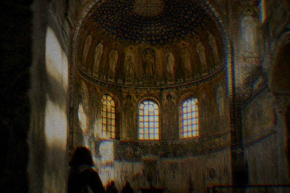 Golden mosaic interior of an old chapel with saints and star patterns under a dome