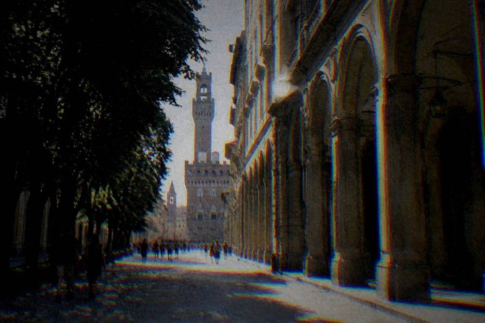 A quiet Italian piazza in soft morning light with café tables and old facades