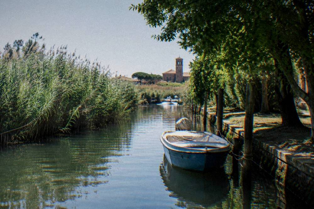 Narrow canal between reed banks with a small moored boat