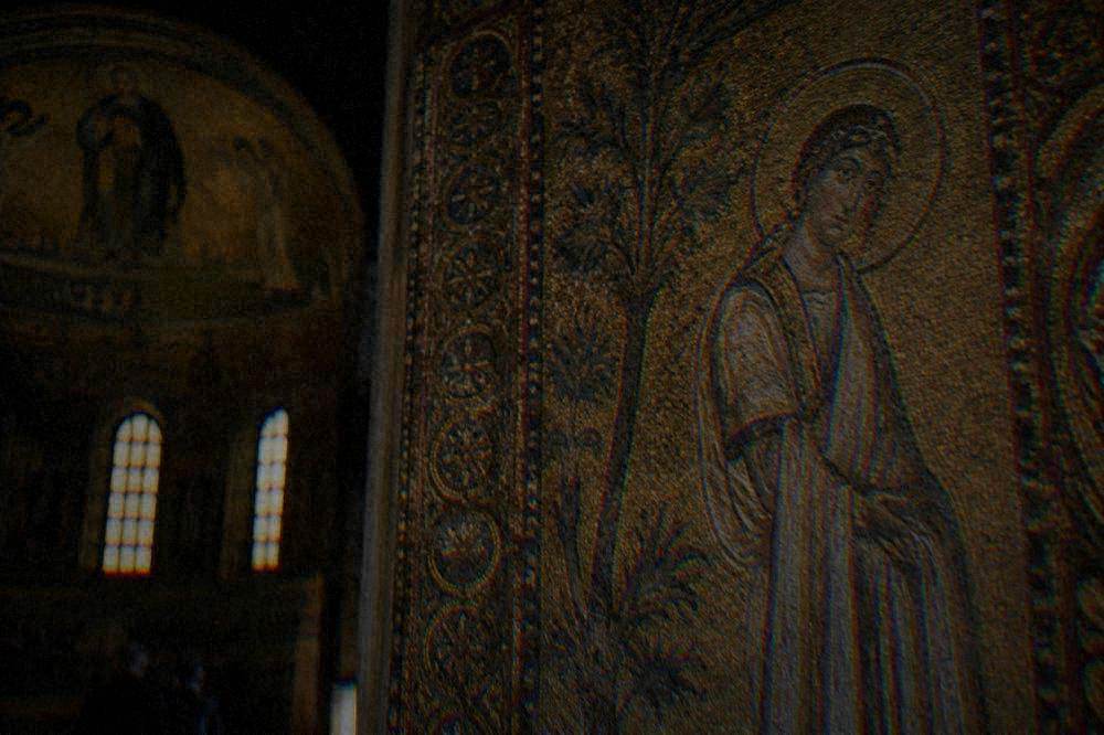 Tiles and details of a gold-ground mosaic inside a dimly lit ancient chapel