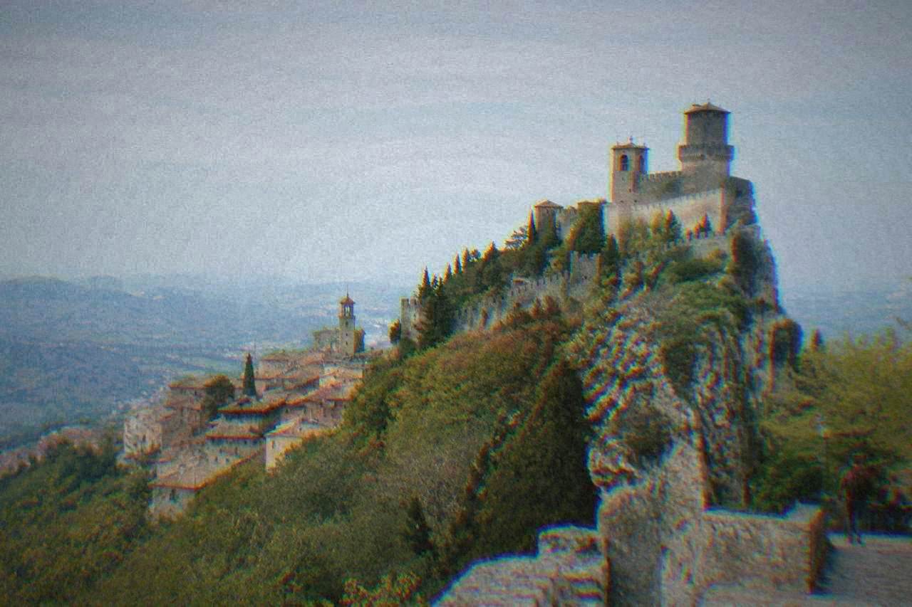 Towered stone old town of San Marino rising on a mountain ridge under a clear sky