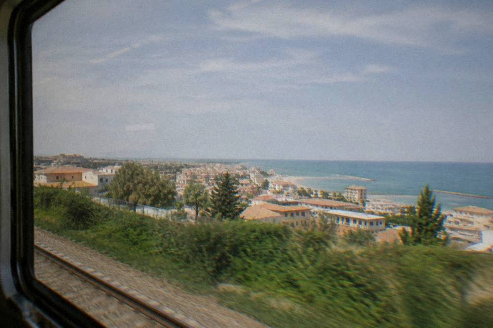 A coastal resort town skyline seen from a train window on a bright day