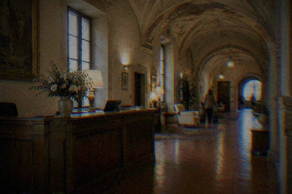 A hotel reception desk in an old Ravenna palazzo with terracotta floors and a vaulted ceiling