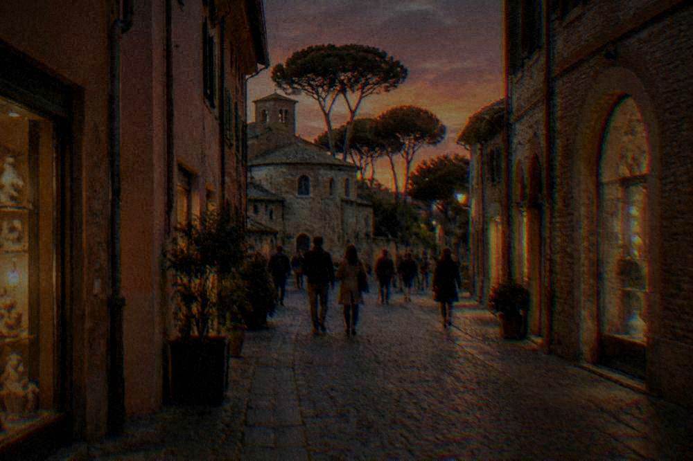 A narrow Ravenna lane at dusk with lit shop windows and people strolling