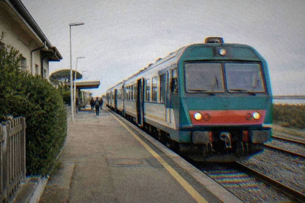 A regional train waiting at a platform in an Italian railway station