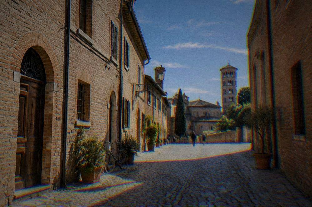 A quiet cobbled street in Ravenna's historic centre lined with old brick buildings