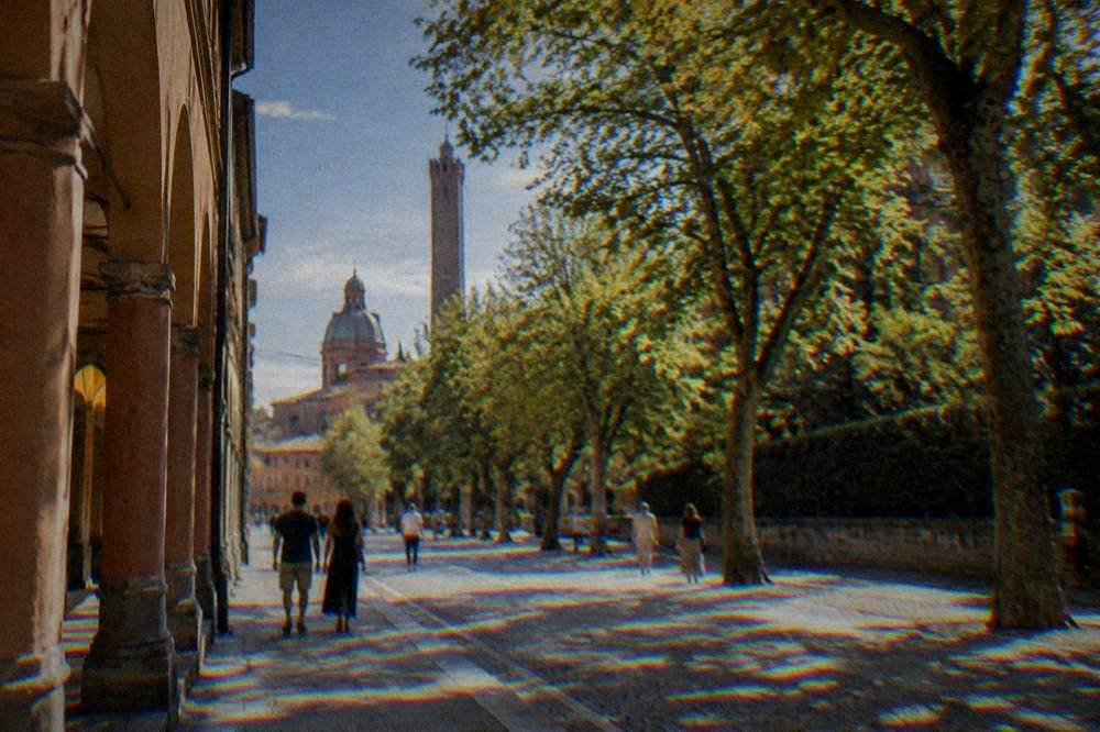 A narrow cobblestone street in an old Italian town lined with bicycles and shuttered windows