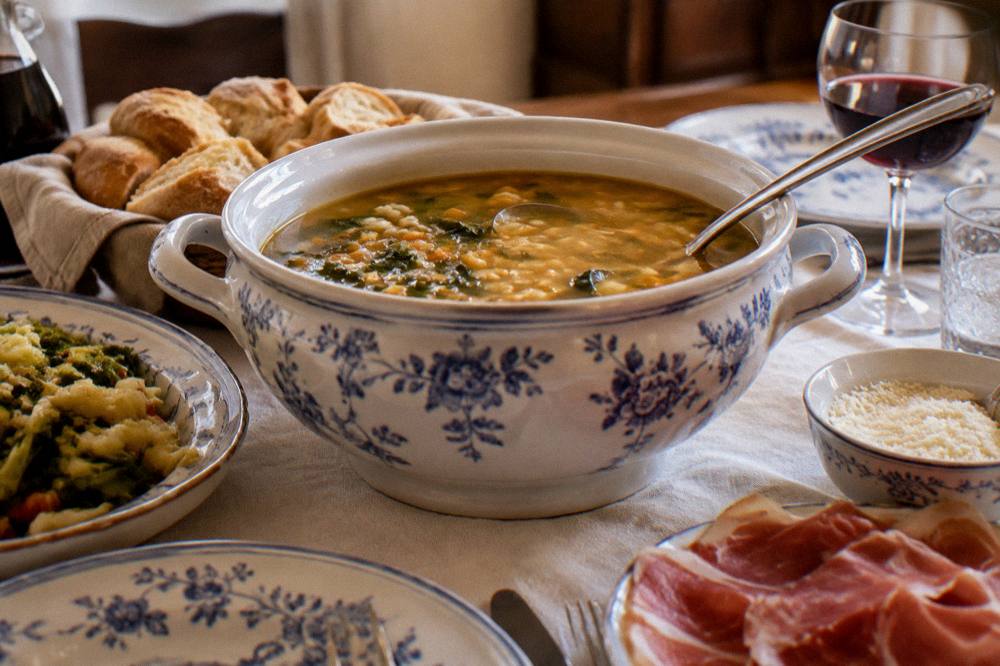 A family table set for a festive lunch with a tureen of soup in the centre