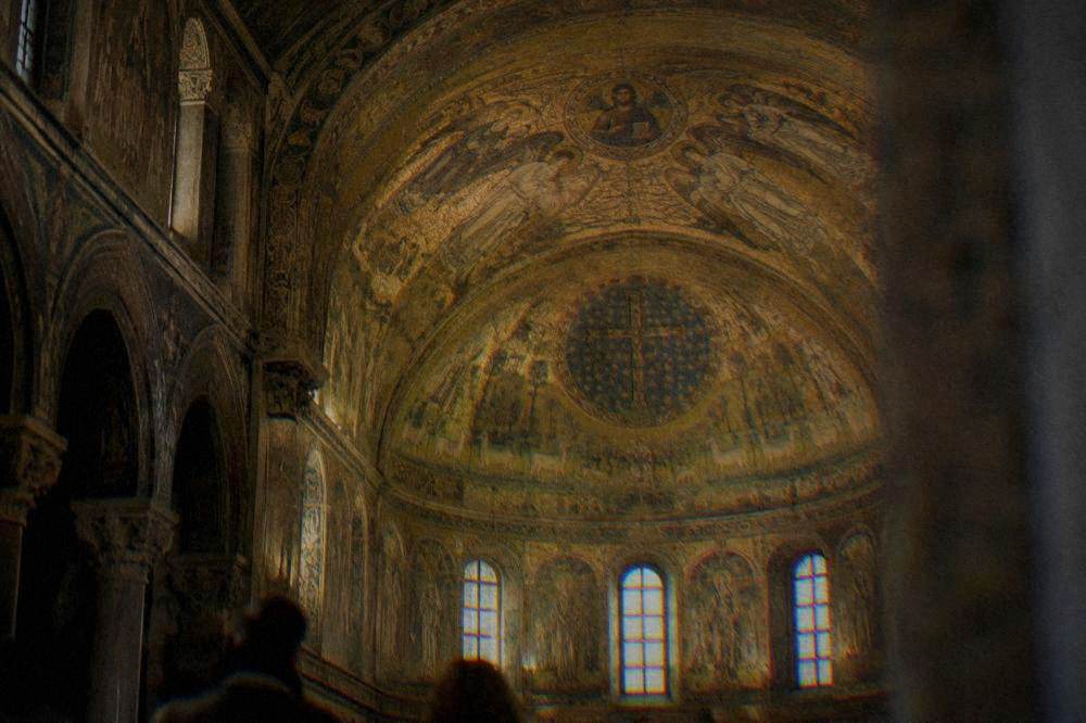 Interior of a Byzantine basilica in Ravenna with green marble columns and mosaic decoration
