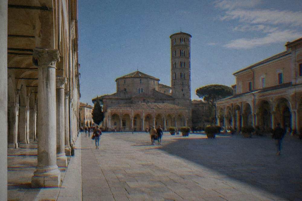 The brick exterior of an early Christian basilica in Ravenna seen from a narrow street