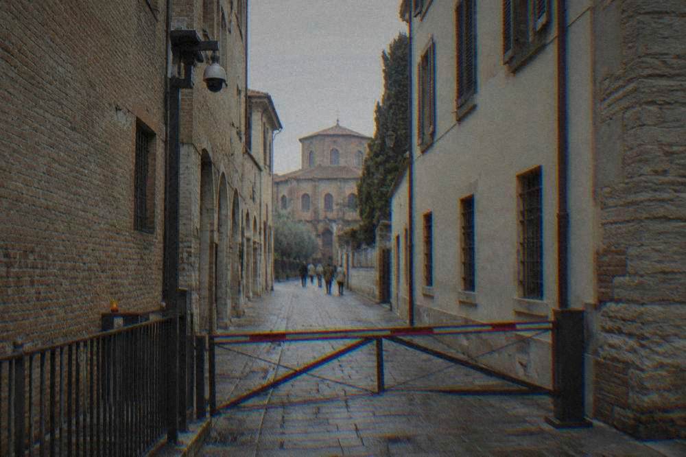 A narrow old street in Ravenna closed to traffic with a camera-monitored access gate