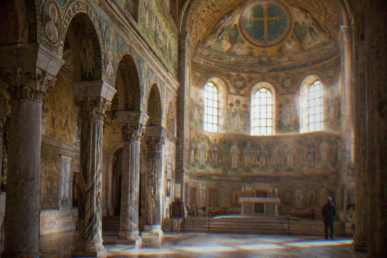Golden mosaic interior of an early Christian church in Ravenna lit by daylight