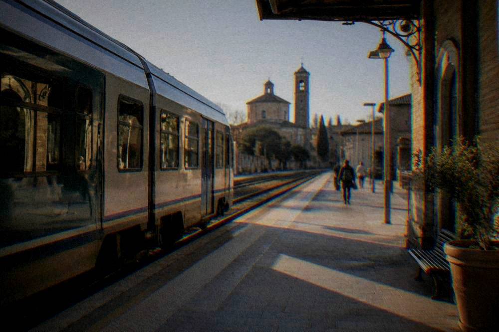 Regional train at a small Italian station platform in morning light