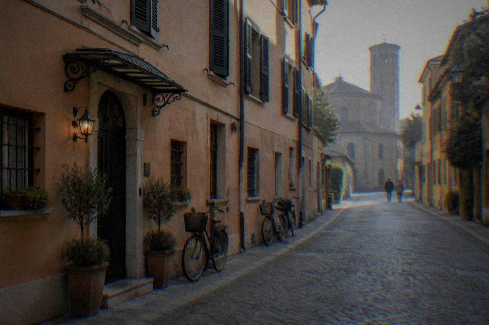 Facade of a small hotel on a quiet street with shutters and bicycles