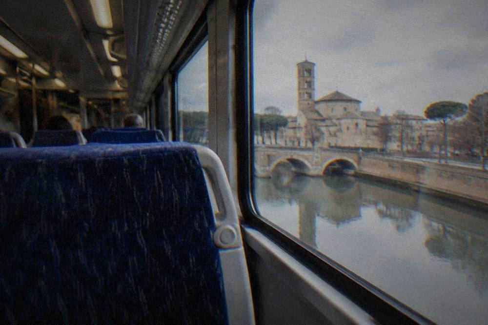The interior of a modern Italian regional train with rows of seats