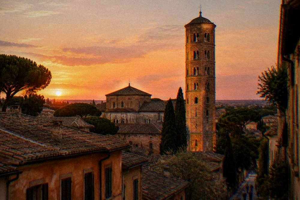 Golden evening light on a brick bell tower above old Italian rooftops
