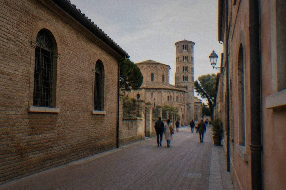People walking through a narrow brick-paved lane in Ravenna's historic centre