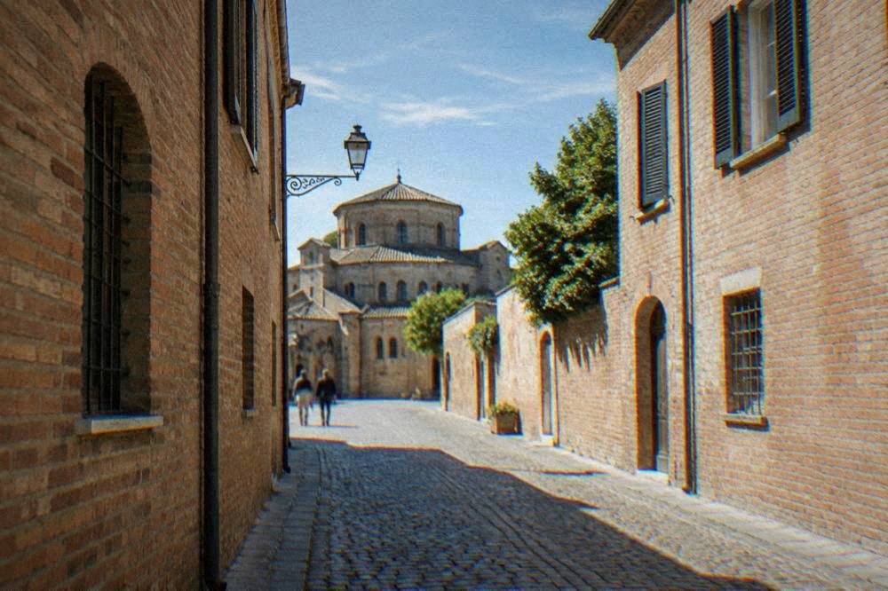 A quiet cobbled street in Ravenna's historic centre lined with old brick buildings