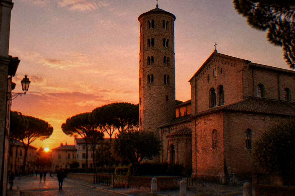 Evening light on the brick facade and bell tower of an old Ravenna church