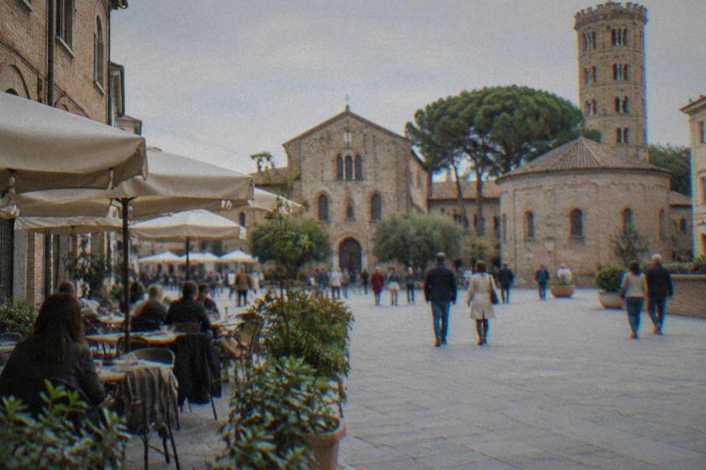 A narrow Ravenna street with parked bicycles and a stone archway