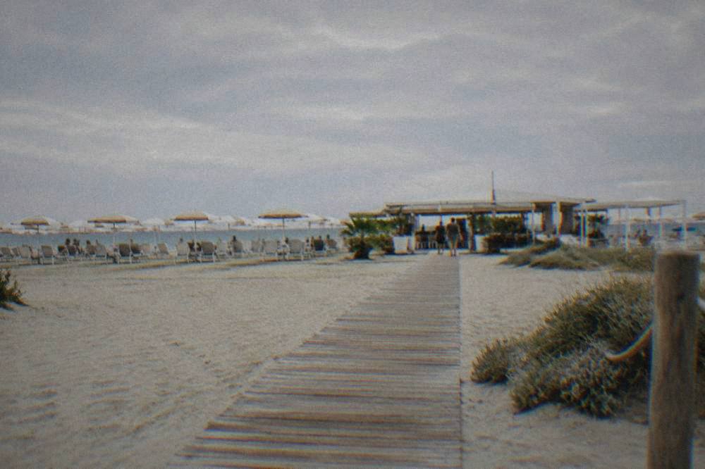 A canal-side square in a small Adriatic resort town with cafe tables and moored boats