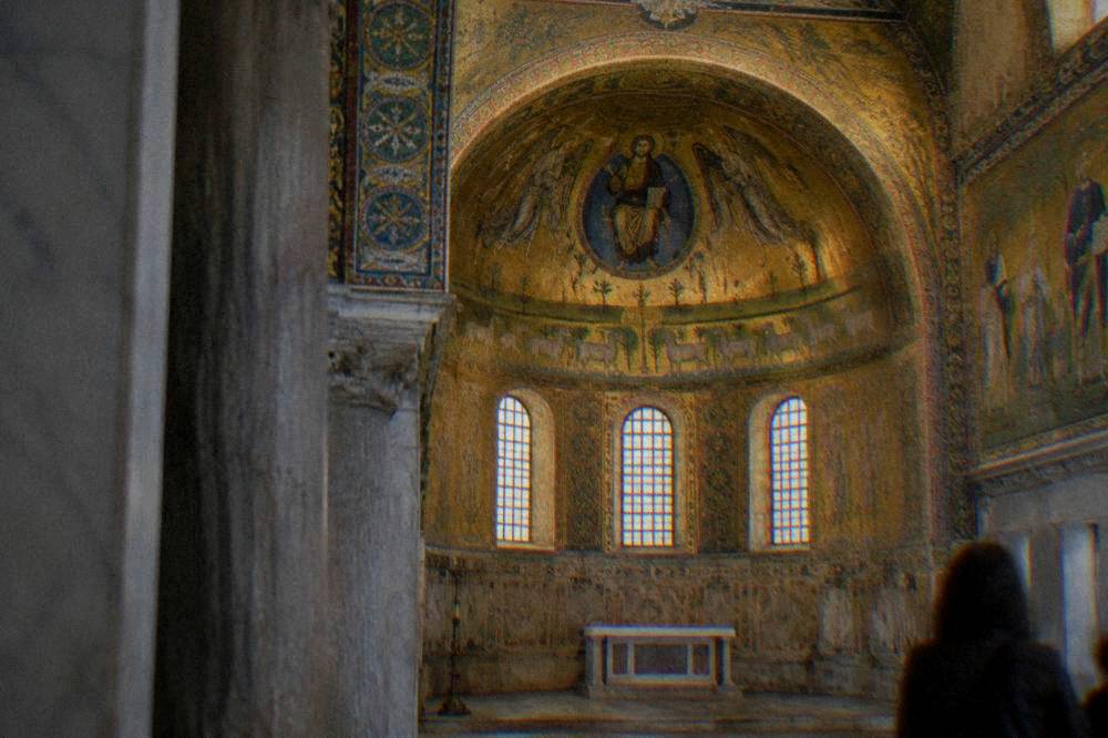 A golden interior of an early Christian chapel lit by mosaic decoration