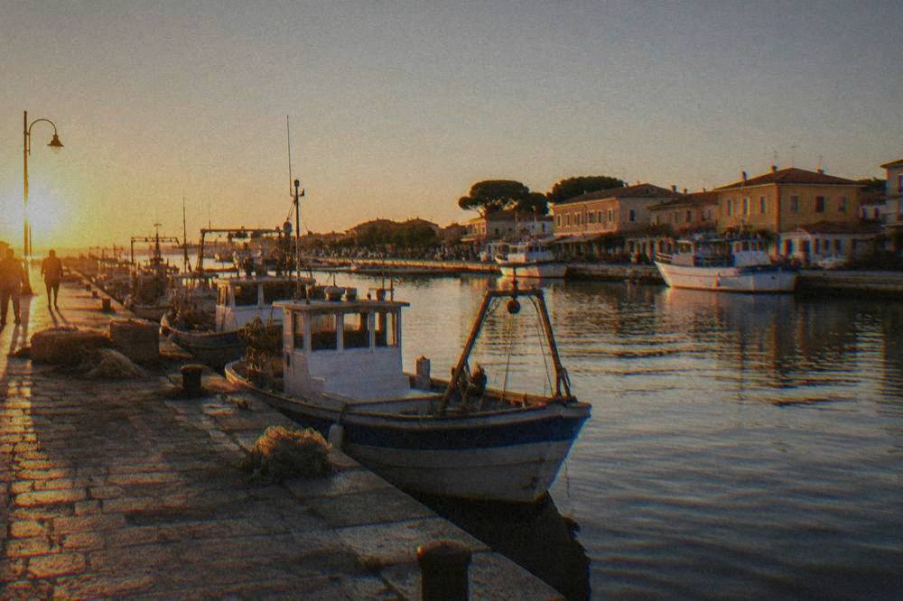 Canal harbour at a seaside resort with moored boats and low buildings under a clear sky