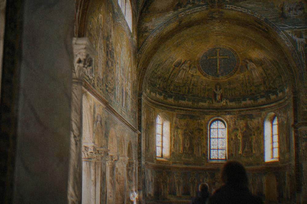Golden mosaic interior of an early Christian chapel lit through small windows