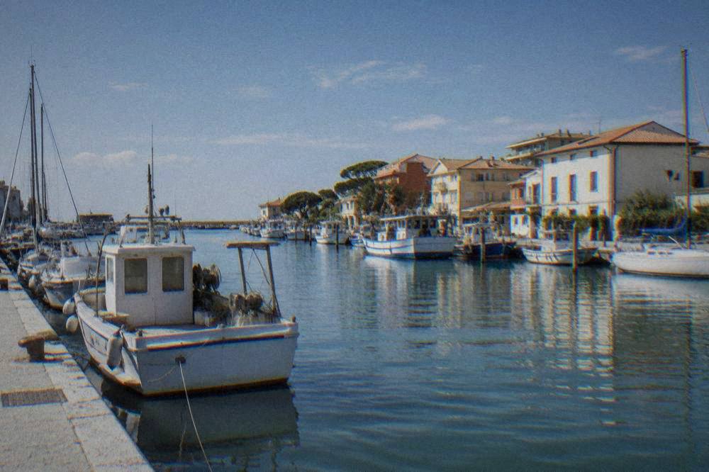 Canal harbour at Marina di Ravenna with moored boats and seaside buildings