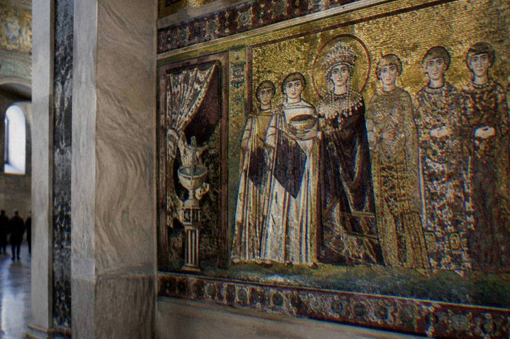 Byzantine mosaic panel of an empress and her court in gold and purple against a gold background