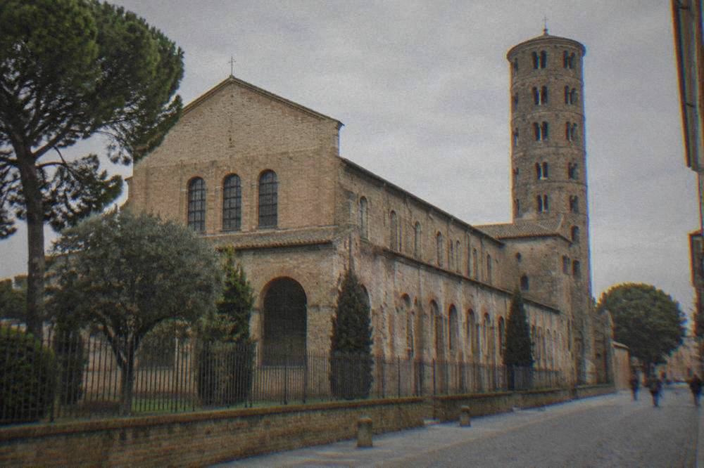 The brick exterior of the basilica of Sant'Apollinare Nuovo in Ravenna seen from the street
