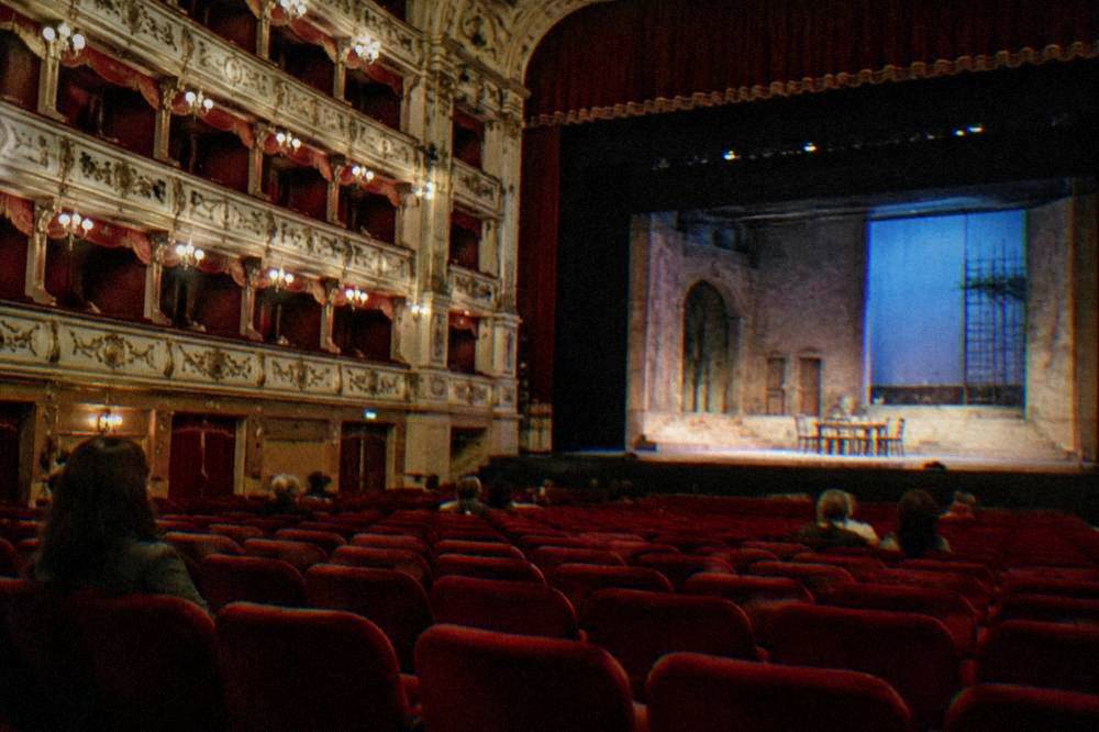 A gilded opera house auditorium with a chandelier and rows of balconies