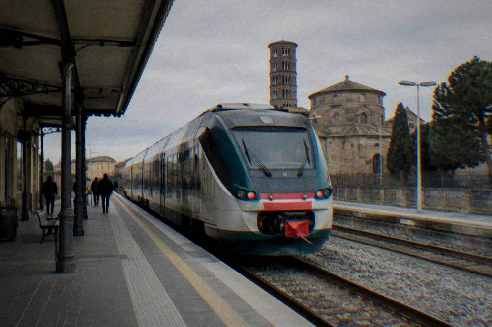 A regional train at Ravenna railway station platform under an overcast sky