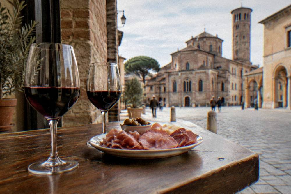 Glasses of red Sangiovese wine and a plate of cured meats on a tavern counter
