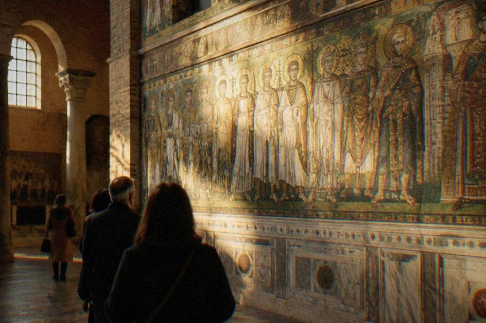 A guide leading a small group through a mosaic-decorated Ravenna church