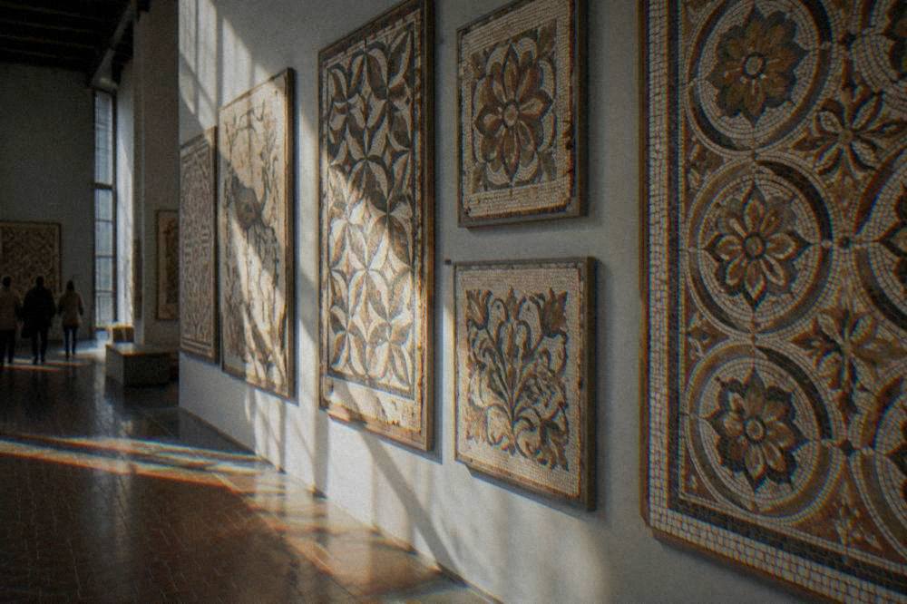 A studio wall covered with finished mosaic panels in geometric and floral patterns