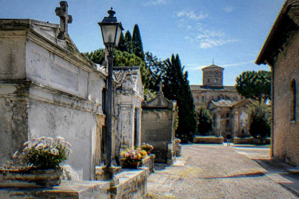 Quiet stone tomb area with a lamp and flowers in Ravenna