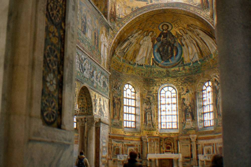 A golden mosaic interior glowing inside an ancient Ravenna monument
