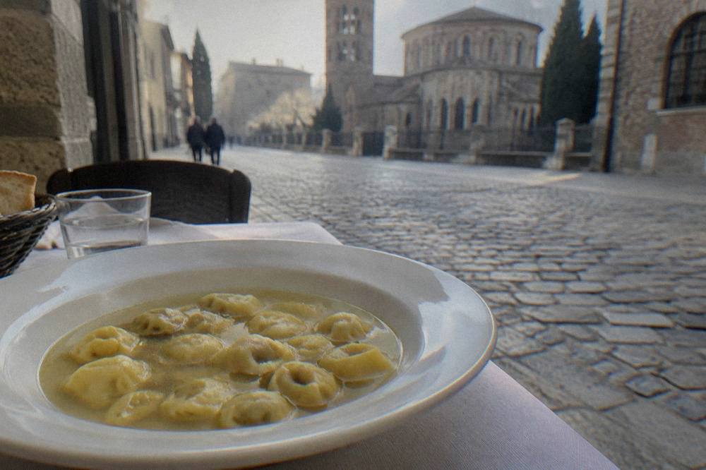A plate of small folded pasta parcels served in clear broth