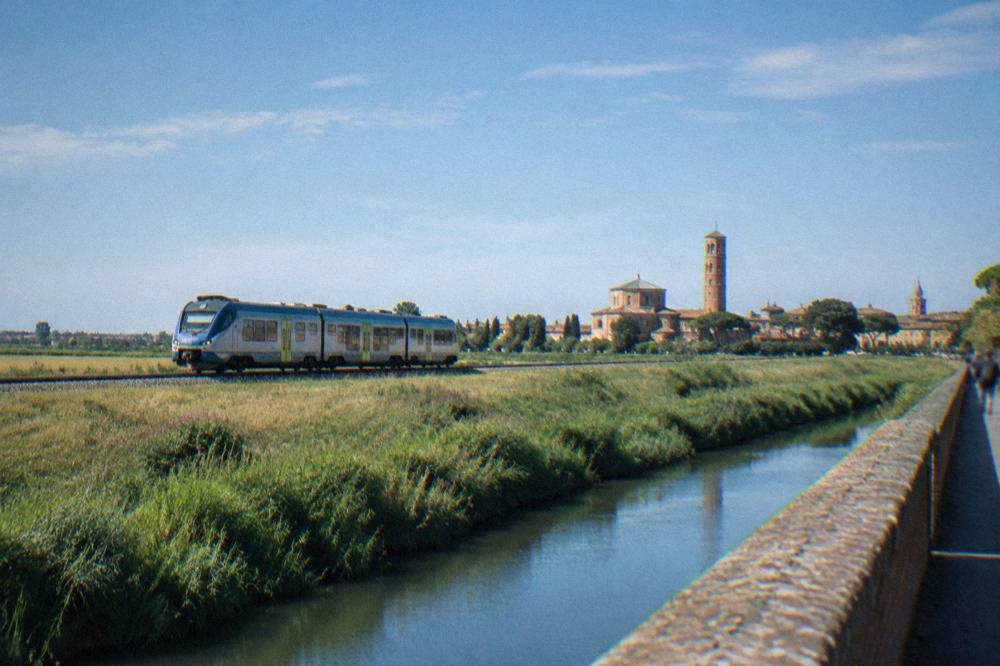 A regional train travelling across the flat Po plain toward Ravenna
