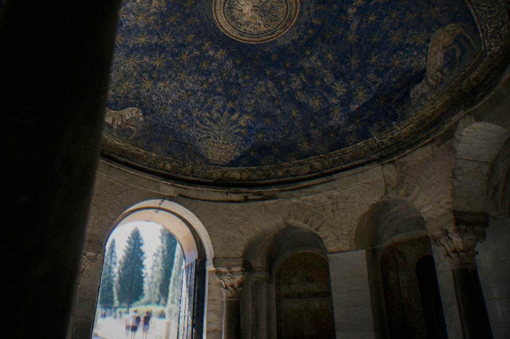 A stone interior with an ornate mosaic dome lit softly from side windows