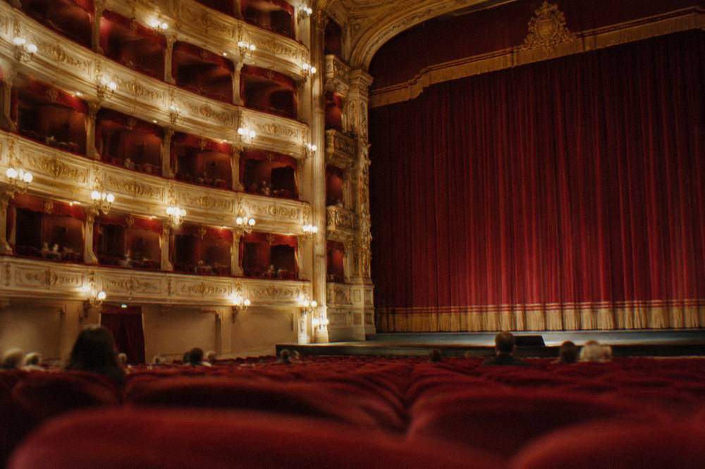 An ornate Italian theatre interior with red seats and gilded balconies