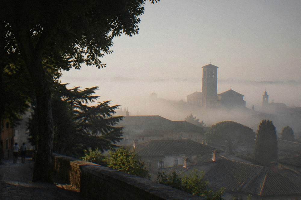 A foggy winter morning along a Ravenna street with brick facades fading into mist