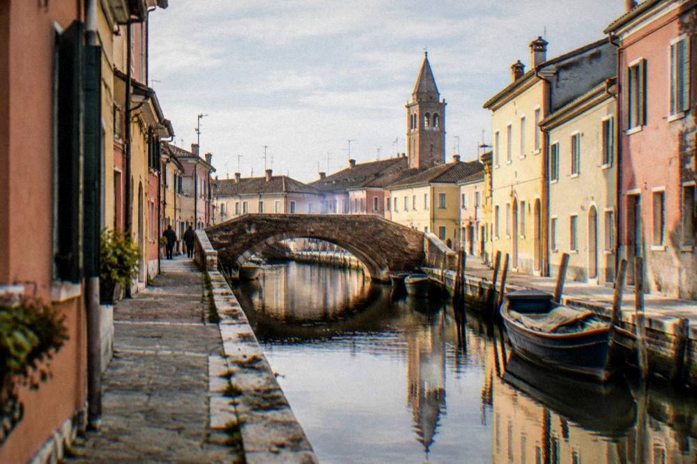 Narrow canals and small bridges in a lagoon town with pastel buildings