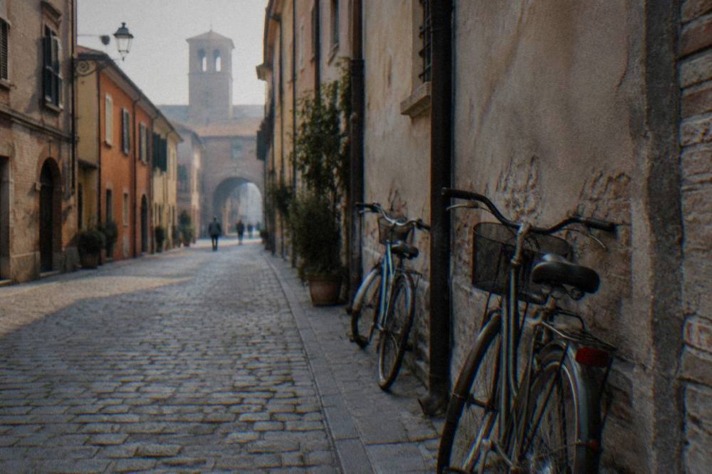 A narrow cobbled street in an old Italian town with bicycles leaning on a wall