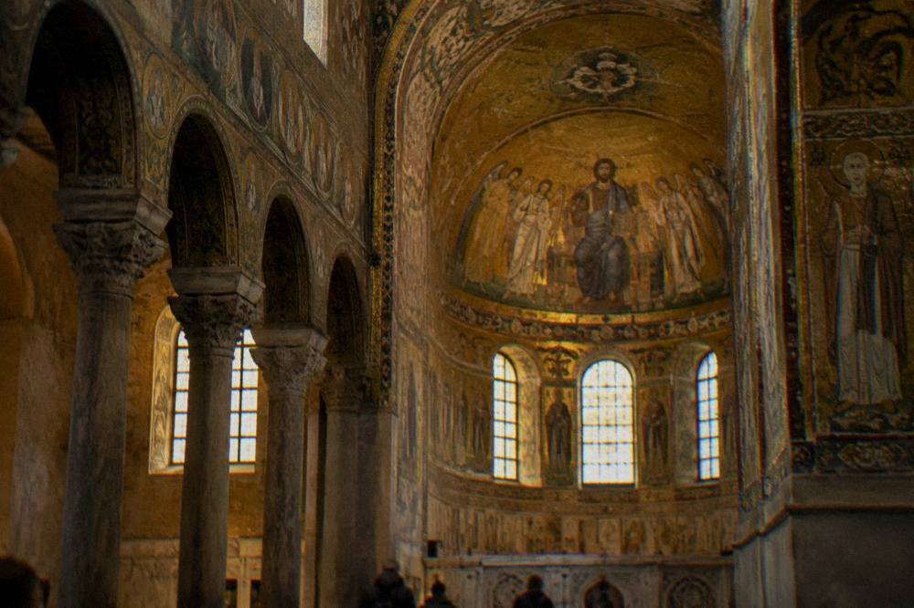A golden Byzantine mosaic interior lit softly inside an old Ravenna church